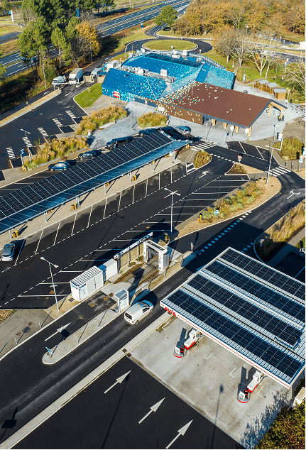 Station de recharge pour véhicules électriques avec panneaux solaires en extérieur.